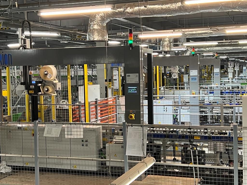 Ten Orion SLAM machines — scan, label, apply, manifest — installed in a live Amazon fulfilment centre